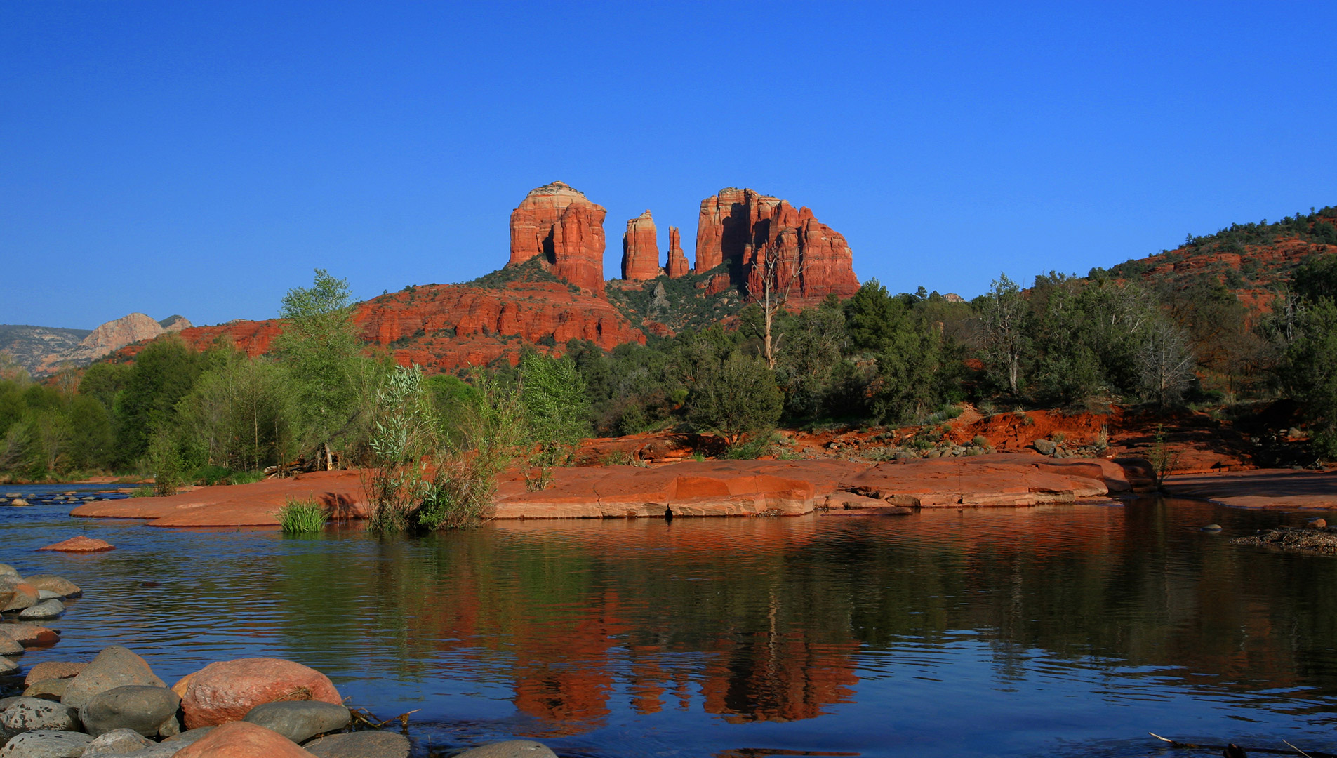 The tranquil waters of Oak Creek meander through Red Rock Crossing, while Cathedral Rock looms in the background