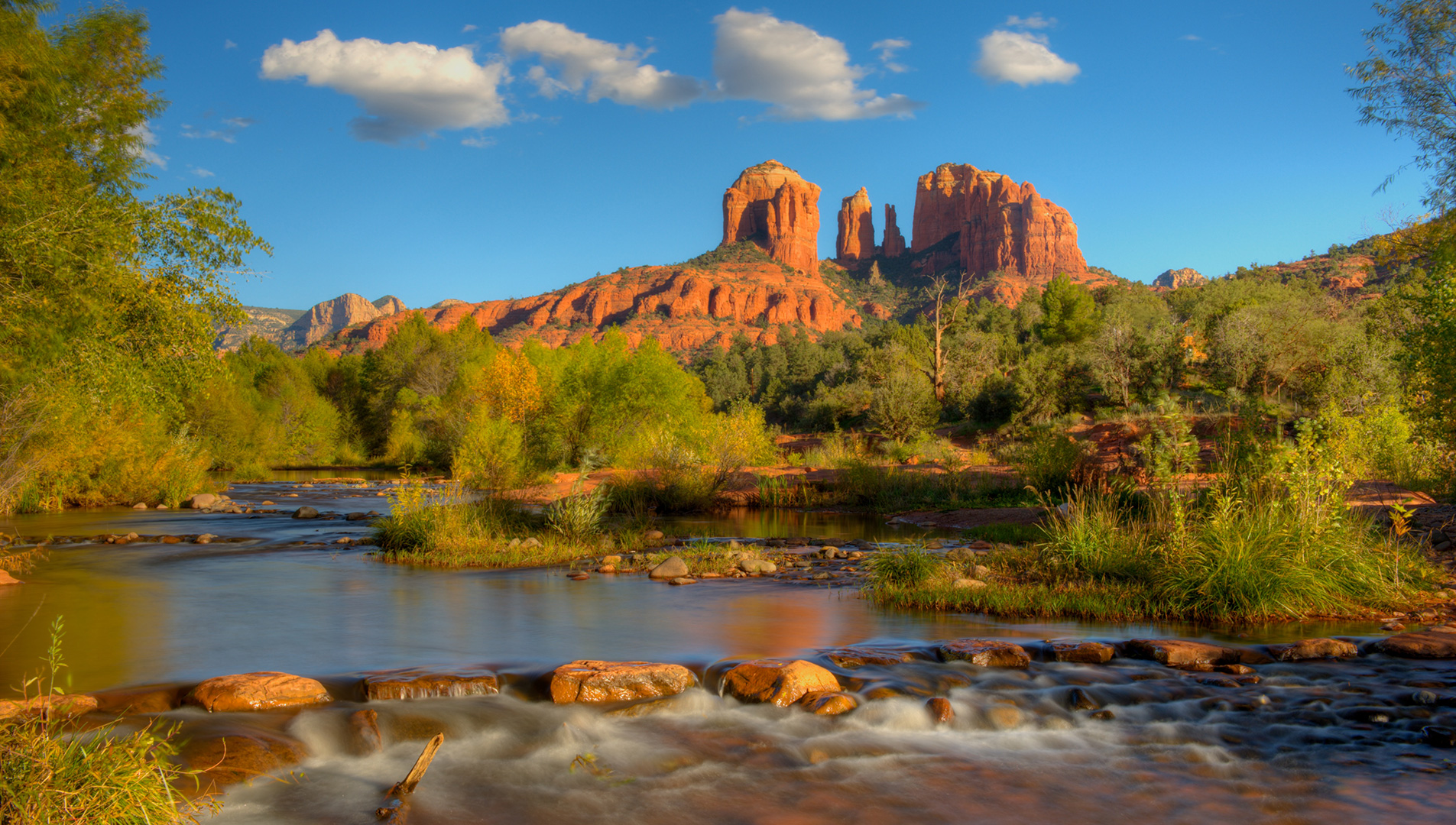Soaring red rock bluffs rise from the placid water of Oak Creek in Sedona’s Red Rock country.